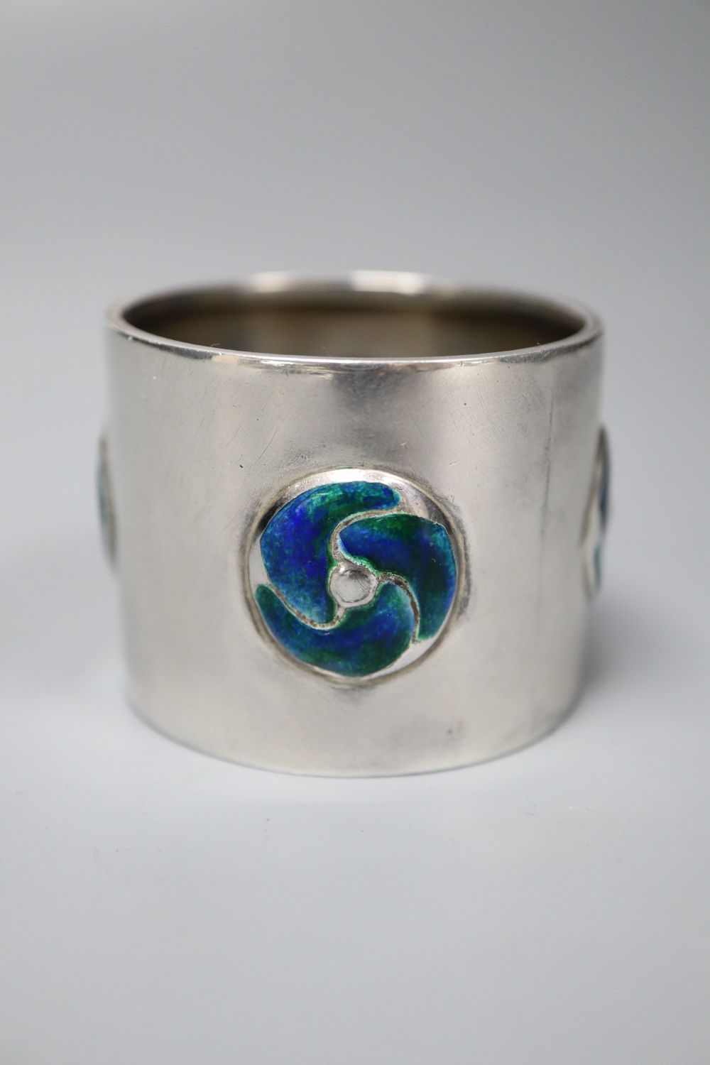 An Edwardian Art Nouveau silver and enamel napkin ring, William Hair Haseler, Birmingham, 1904, 38mm, gross 40 grams.